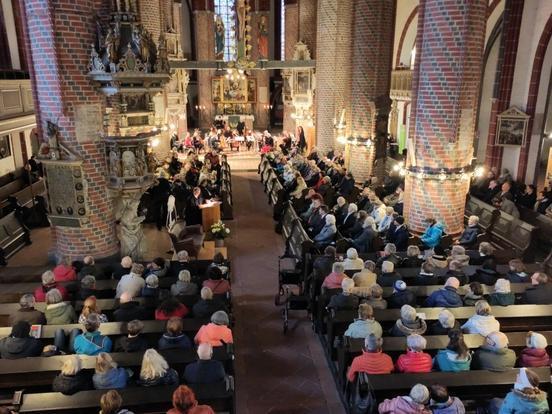 Volle Sitzreihen in der St. Gotthardkirche, Orchester sitzt auf der Bühne