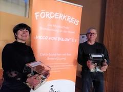 Zwei Personen mit Spendenboxen