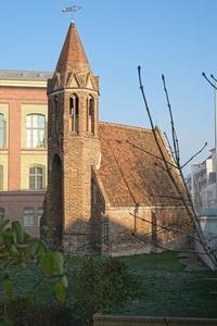 Jakobikirche Brandenburg an der Havel: Backsteinkapelle mit achteckigem Turm und spitzem Kirchendach. Auf dem Turm ist eine Wetterfahne, davor Wiese.