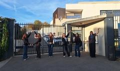 5 Schüler und eine Lehrerin, die die Buchstaben OTOS mit Ihren Körpern vo dem Schulgebäude darstellen