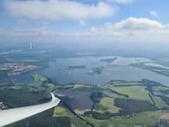 Segelflieger über eine Seenlandschaft.