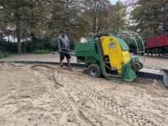 Ein Arbeiter frischt am Trauerberg den Sand auf.