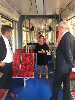 Zwei Politiker stehen in einer Straßenbahn
