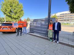 Gruppenfoto am Werbebanner