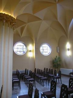 Heller Raum mit vielen Stühlen, runde Fenster, außergewöhnliches Deckengewölbe