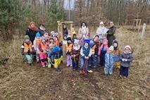 Eine Kindergartengruppe vor einem gepflanzten Baum.