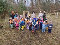 Eine Kindergartengruppe vor einem gepflanzten Baum.