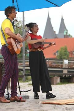 Mann und Frauen spielen GItarre