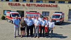 OB Steffen Scheller (3. von re.) und der Beigeordnete Thomas Barz (6. von re.) übergaben die Krankenwagen an das Rettungsteam