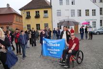 Athletensprecher Jörg Hübener mit Plakat "Teilhabe ist Menschenrecht".