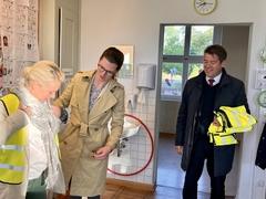 Rektorin Sabine Specker zeigt, wie die Warnweste richtig angezogen wird.