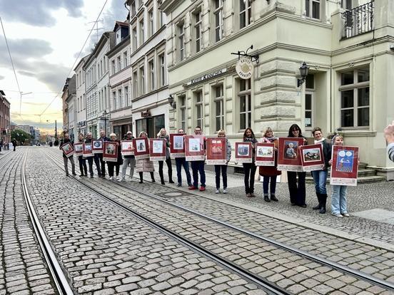 viele Menschen stehen in einer Reihe und halten Plakate hoch.