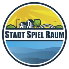 Logo rund mit Schrift in der Mitte (STADTSPIELRAUM). über der Schrift sind Häuser, Bäume, Laternen und eine Brücke als Stadt dargestellt.