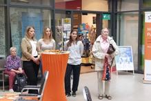 Ein Stand im Atrium, um den sich Menschen versammelt haben