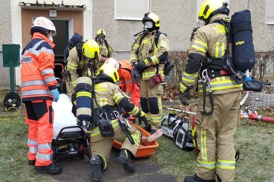 Simulation einer Rettung - Feuerwehrleute und Rettungsdienst versorgen eine menschengroße Rettungspuppe
