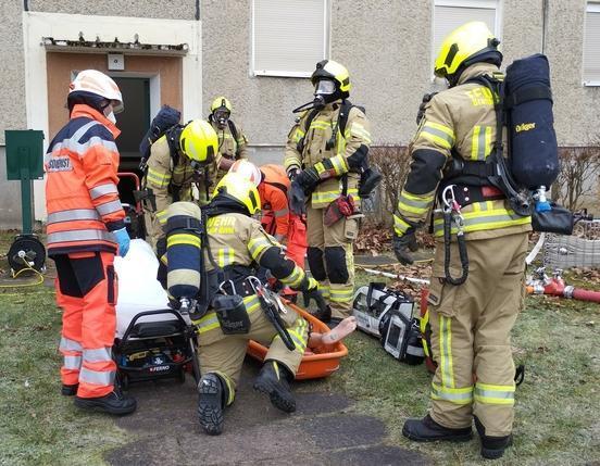 Simulation einer Rettung - Feuerwehrleute und Rettungsdienst versorgen eine menschengroße Rettungspuppe