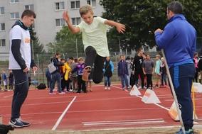 Kind springt in Weitsprunggrube.