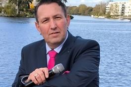 Der Sänger vor einem Wasserhintergund.