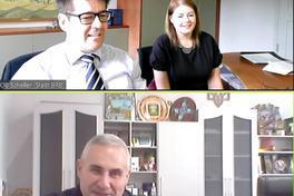 Mann und Frau sitzen mebeneinander am Schreibtisch und lächeln