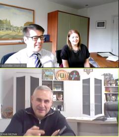 Mann und Frau sitzen mebeneinander am Schreibtisch und lächeln