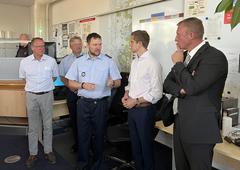 5 Männer stehen in der Leitstelle