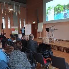 Eine Gruppe Menschen hört sich bei der Veranstaltung einen Beitrag zur Mobilität an