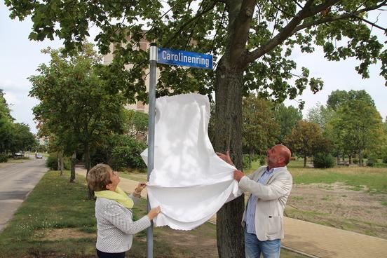 Oberbürgermeisterin Dr. Dietlind Tiemann und Hartmut Schulz enthüllen das neue Straßennamensschild.