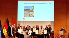 Eine Menschengruppe erhält eine Auszeichnung.