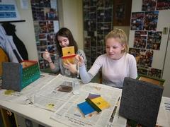 Schülerinnen verzieren die Nistkästen im Krugpark