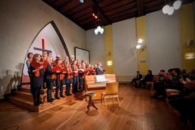 singende Chormitglieder, die vom Publikum beklatscht werden.