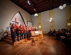 singende Chormitglieder, die vom Publikum beklatscht werden.