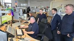 Beigeordneter Thomas Barz, Steffen Scheller und Feuwehrleiter Sebastian Kalka schauen in der Leitstelle Bernd Karge über die Schulter