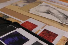 Foto von Bildern und Skizzen liegend auf einem Tisch im Atelier von der Künstlerin Stefanie Rinkenbach.