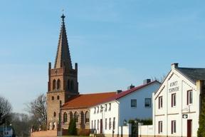 Kirchengebäude mit Kirchenturm und andere zweistöckige Häuser