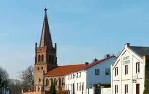 Kirchengebäude mit Kirchenturm und andere zweistöckige Häuser