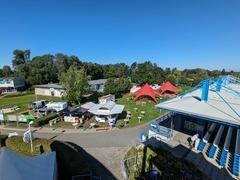 Zelte und Tische hinter der Zuschauertribüne der Regattastrecke