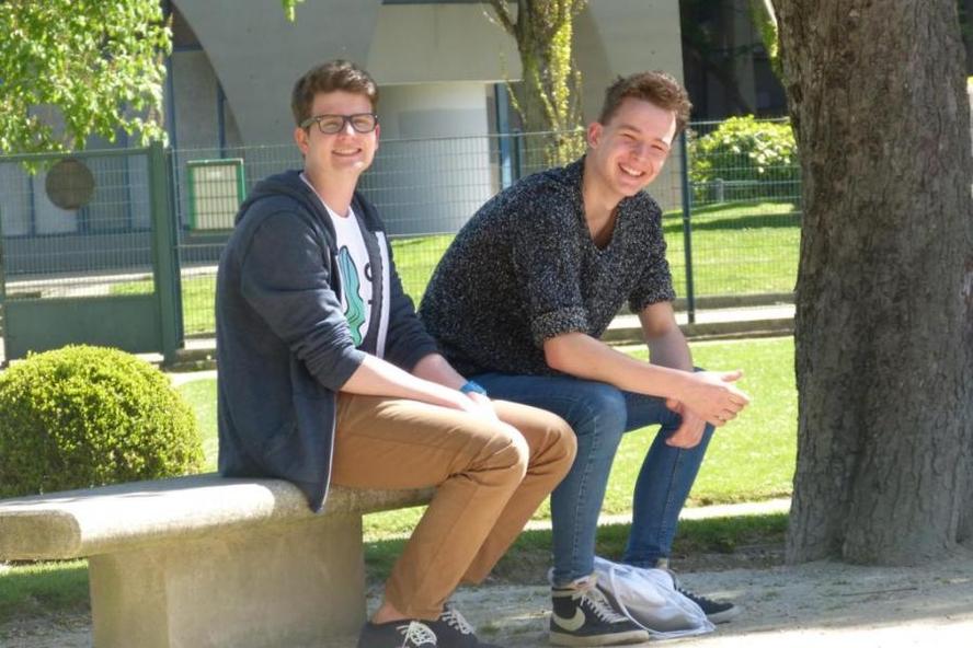 zwei sitzende lachende Jugendliche