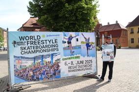Cheforganisator Christian Heise vor dem Werbebanner am Altstädtischen Rathaus