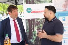 Der Oberbürgermeister unterhält sich mit einem Mann, der die App "Gut versorgt in Brandenburg an derr Havel" vorstellt.