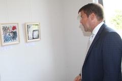 Steffen Scheller schaut sich künstlerische Werke von Studierenden zur Euthanasie an.