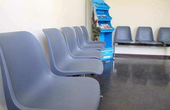 Ein Wartebereich beim Bürgerservice. Graue Stühle an der Wand.
