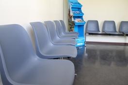 Ein Wartebereich beim Bürgerservice. Graue Stühle an der Wand.