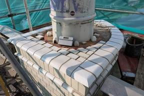 neu aufgebauter Pfeiler mit sichtbarem Betonsockel