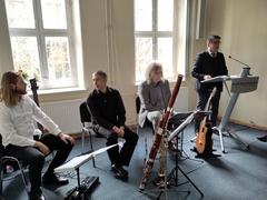 der Oberbürgermeister steht am Rednerpult, neben ihn sitzen 3 Musiker an ihren Instrumenten