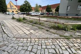 Der kaputte Gehweg in der Beethovenstraße, im Hintergrund die Wilhelm-Busch-Schule.