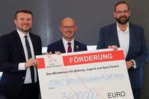 Finanzminister Daniel Keller mit OB Keip und Sportminister Hoffmann bei der Scheckübergabe.