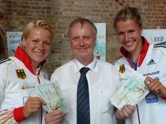 Tina Dietze (links) und Franziska Weber (rechts), Olympiasiegerinnen 2012 und „Gesichter“ der diesjährigen Kanu-EM, präsentieren gemeinsam mit Chef-Organisator Michael Kenzler die Eintrittskarten für das Highlight der Wettkampfsaison 2014 in Brandenburg an der Havel.