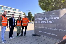 Gruppenfoto am Werbebanner