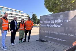 Gruppenfoto am Werbebanner