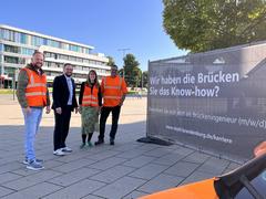 Gruppenfoto am Werbebanner